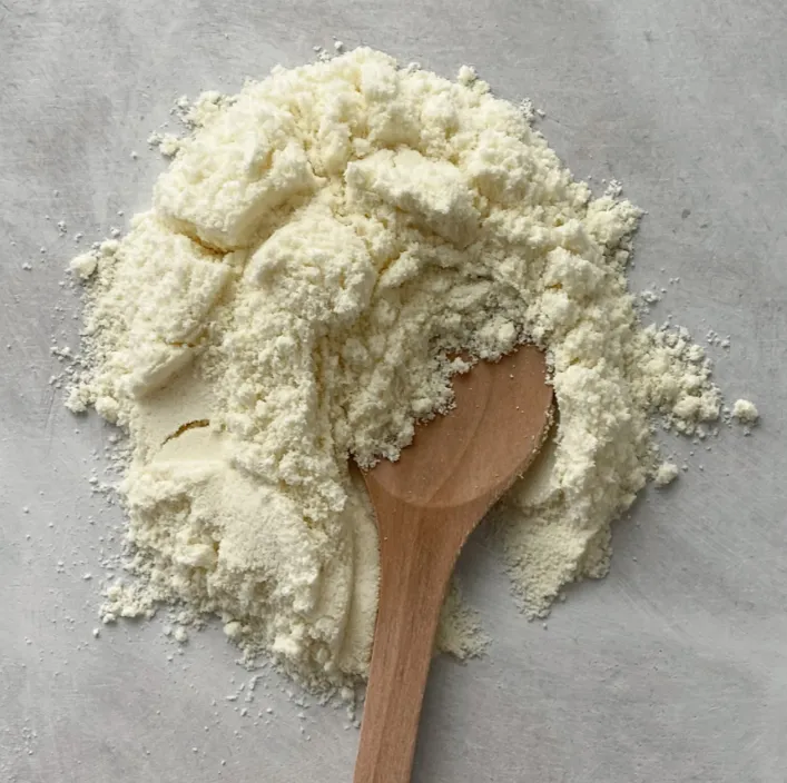 Non-animal casein powder with a wooden spoon