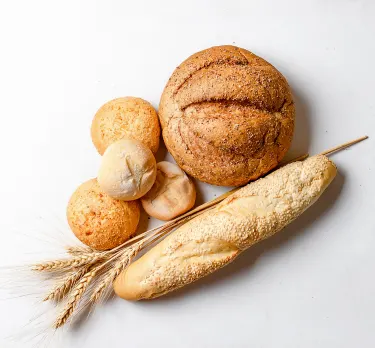 Bread rolls and a baguette with ears of wheat