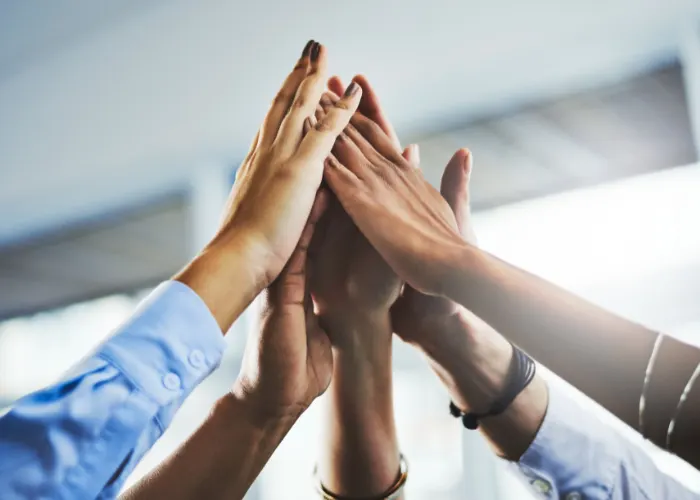 Several hands meeting in a high five