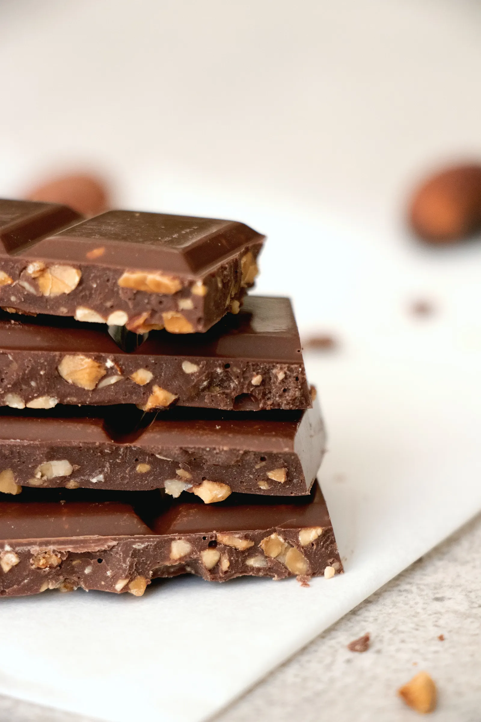 Pieces of dark chocolate with nuts on a dark surface