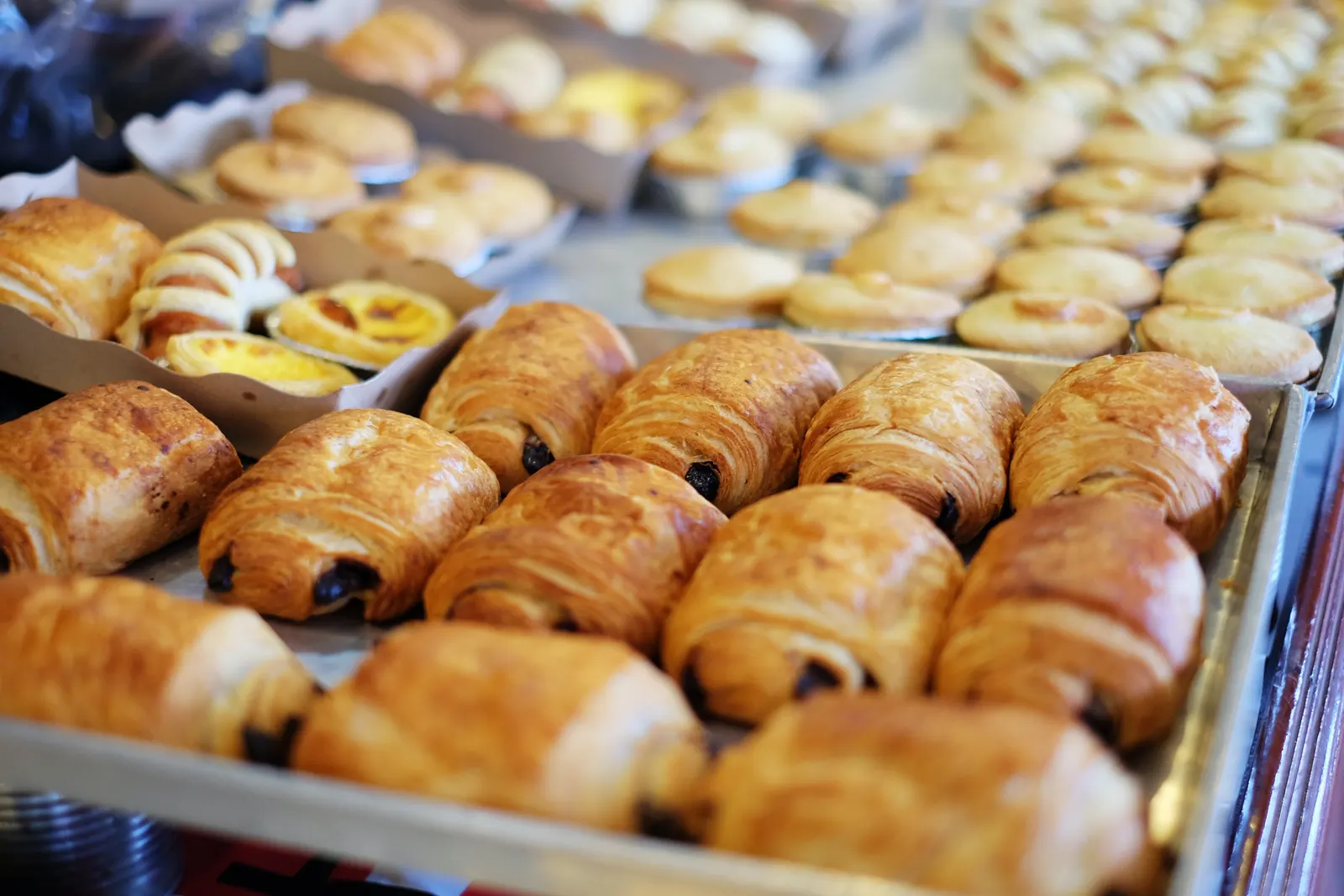 Trays of croissants and pains au chocolat in a bakery